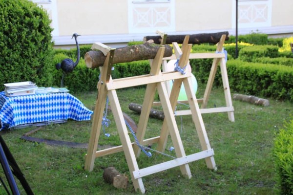 Eine Stationen einer Team-Challenge: ein Sägebock mit Holz und einer Säge auf dem Boden